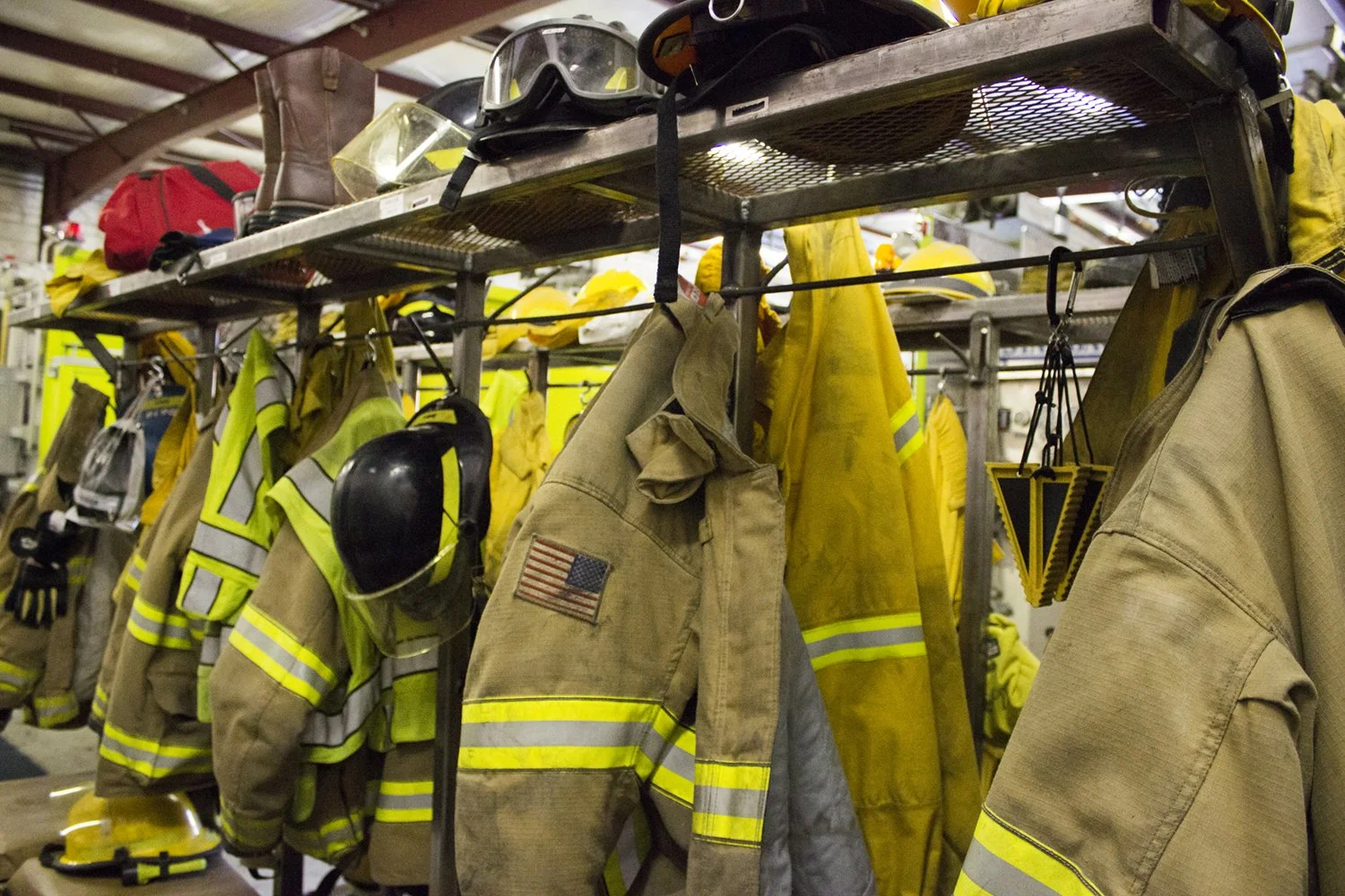 Firefighter turnout coats hanging in a fire station